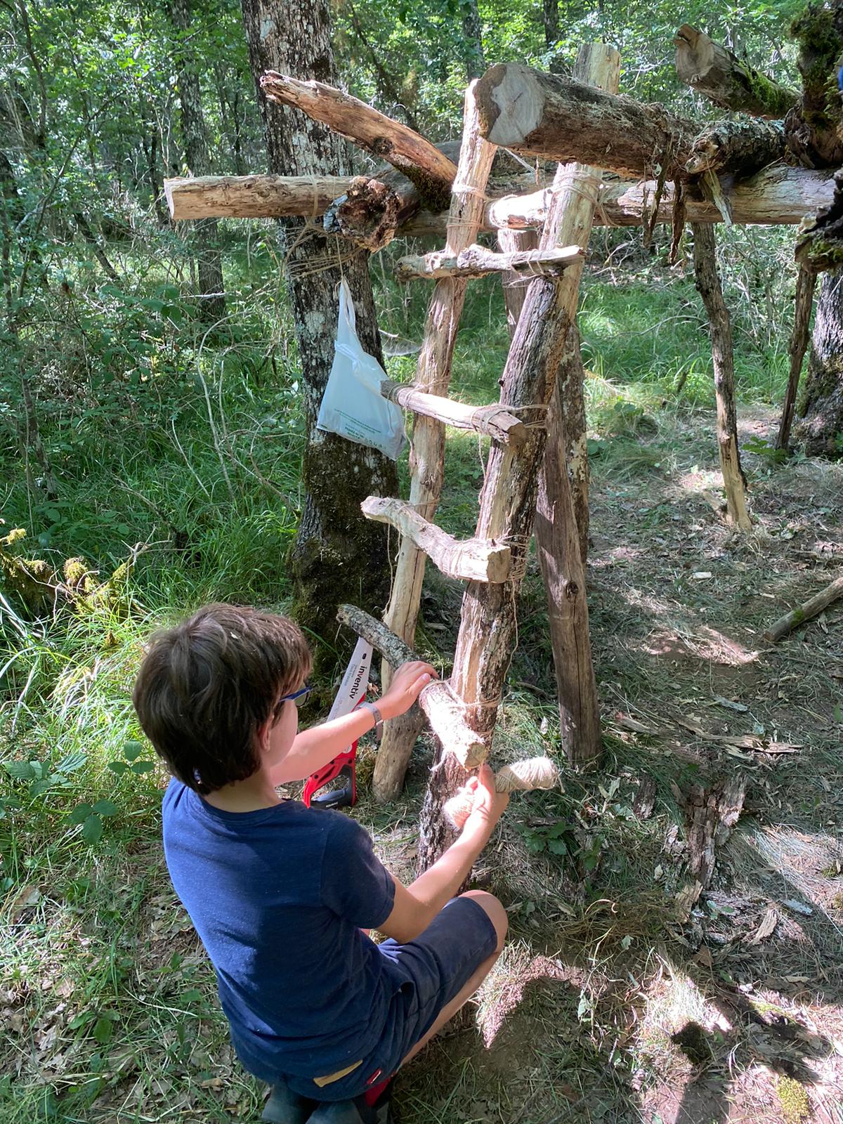 Structure de cabane en cours d'élaboration pendant le camp de vacances aventure