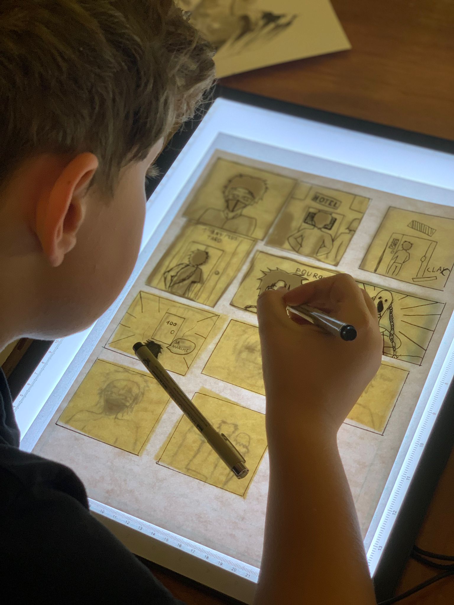 Jeunes artistes dessinant au feutre noir durant une colonie de vacances manga