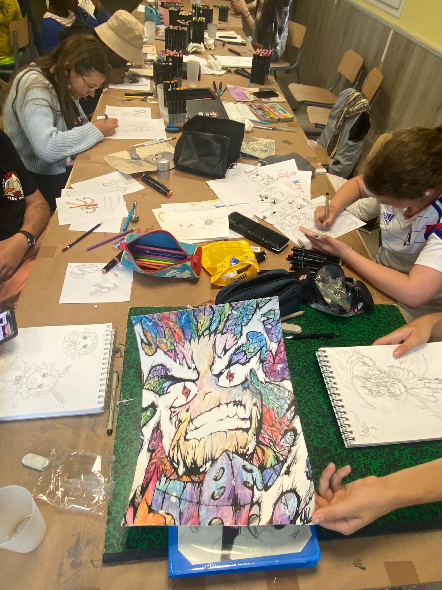 Jeunes participants travaillant l'encrage manga durant leur colonie de vacances