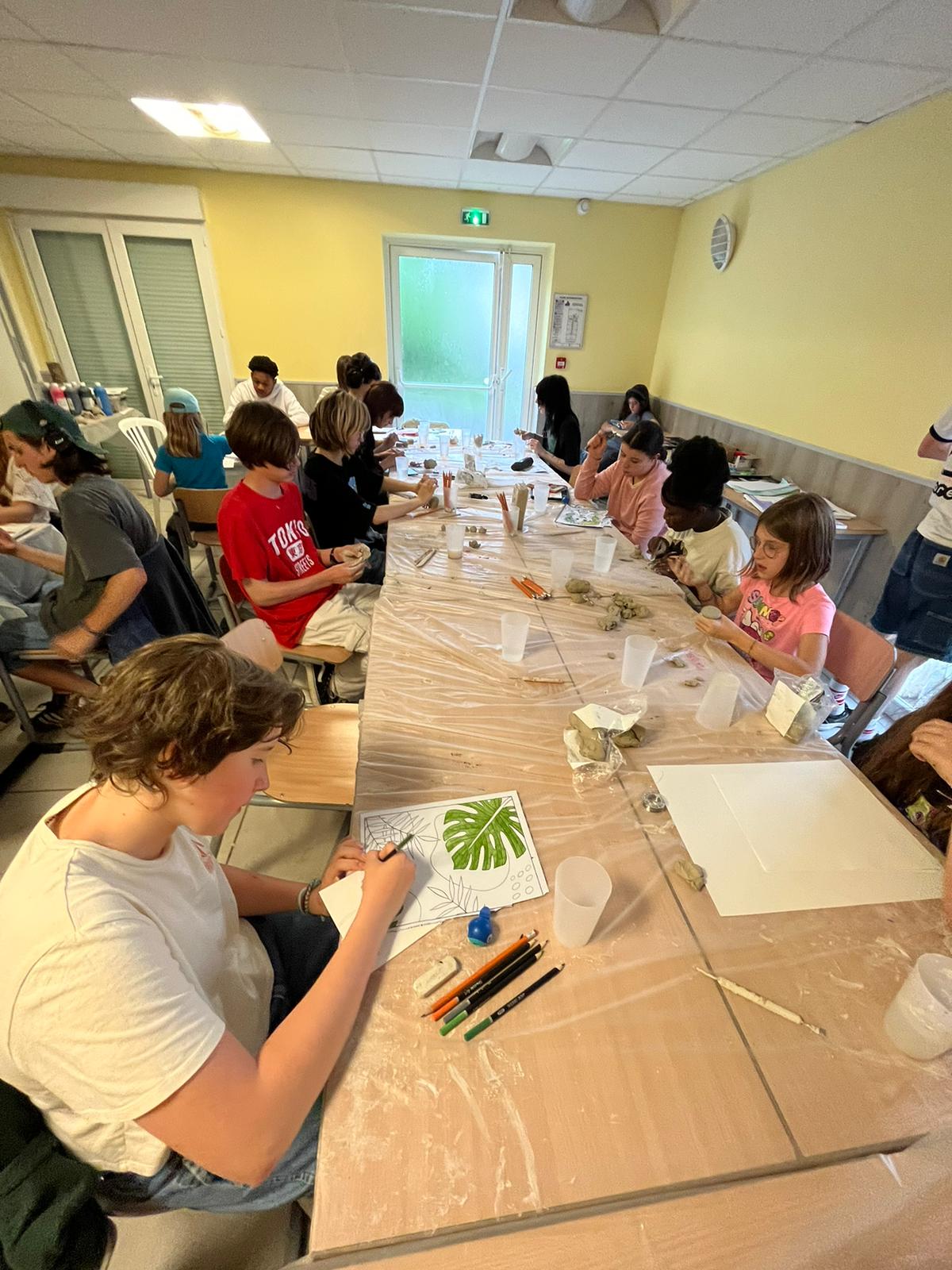 Groupe d'enfants peignant une fresque collective en séjour arts plastiques gocolo