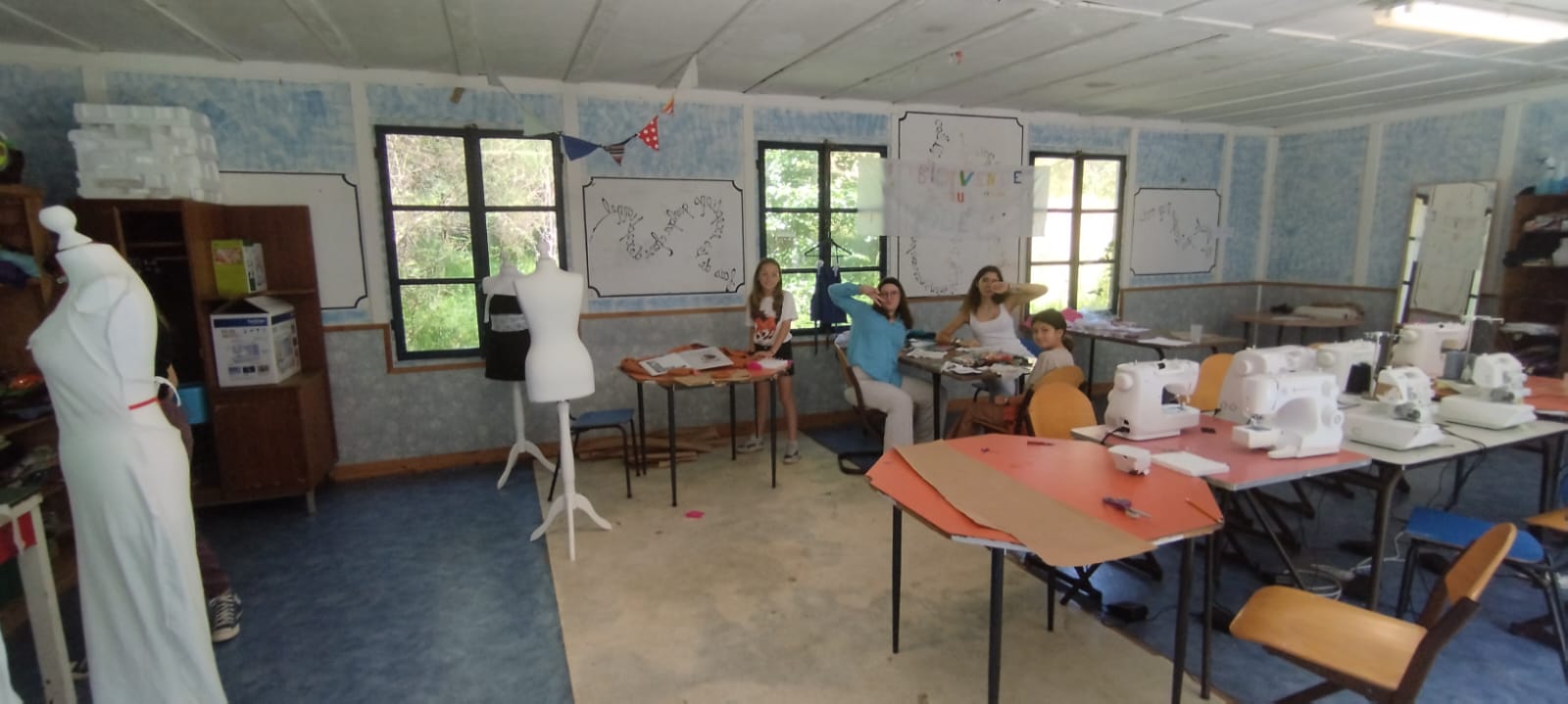 Groupe d'apprentis stylistes cousant des vêtements en colo mode