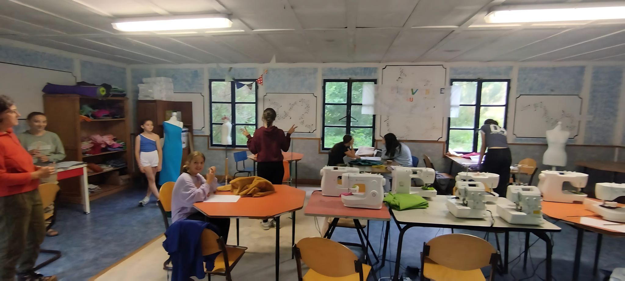 Groupe de stylistes en herbe traçant des patrons en colo créative