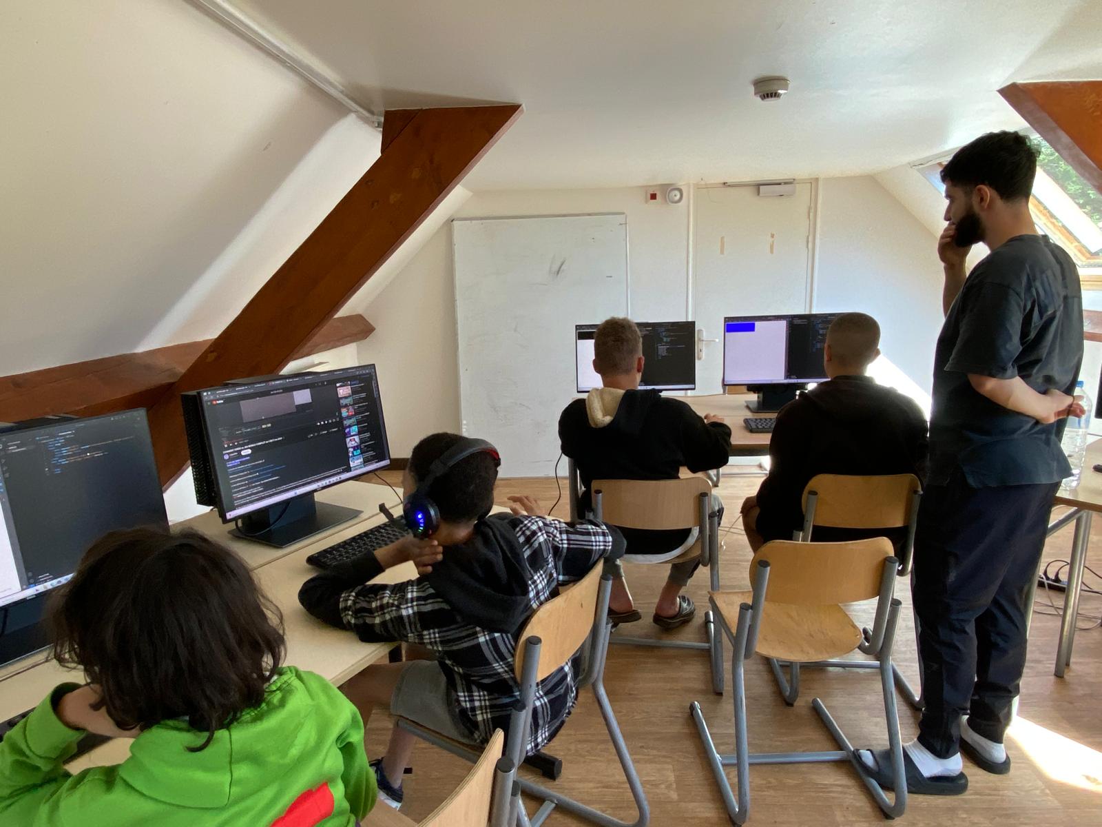 Groupe de jeunes codeurs travaillant sur leur projet en colo gocolo