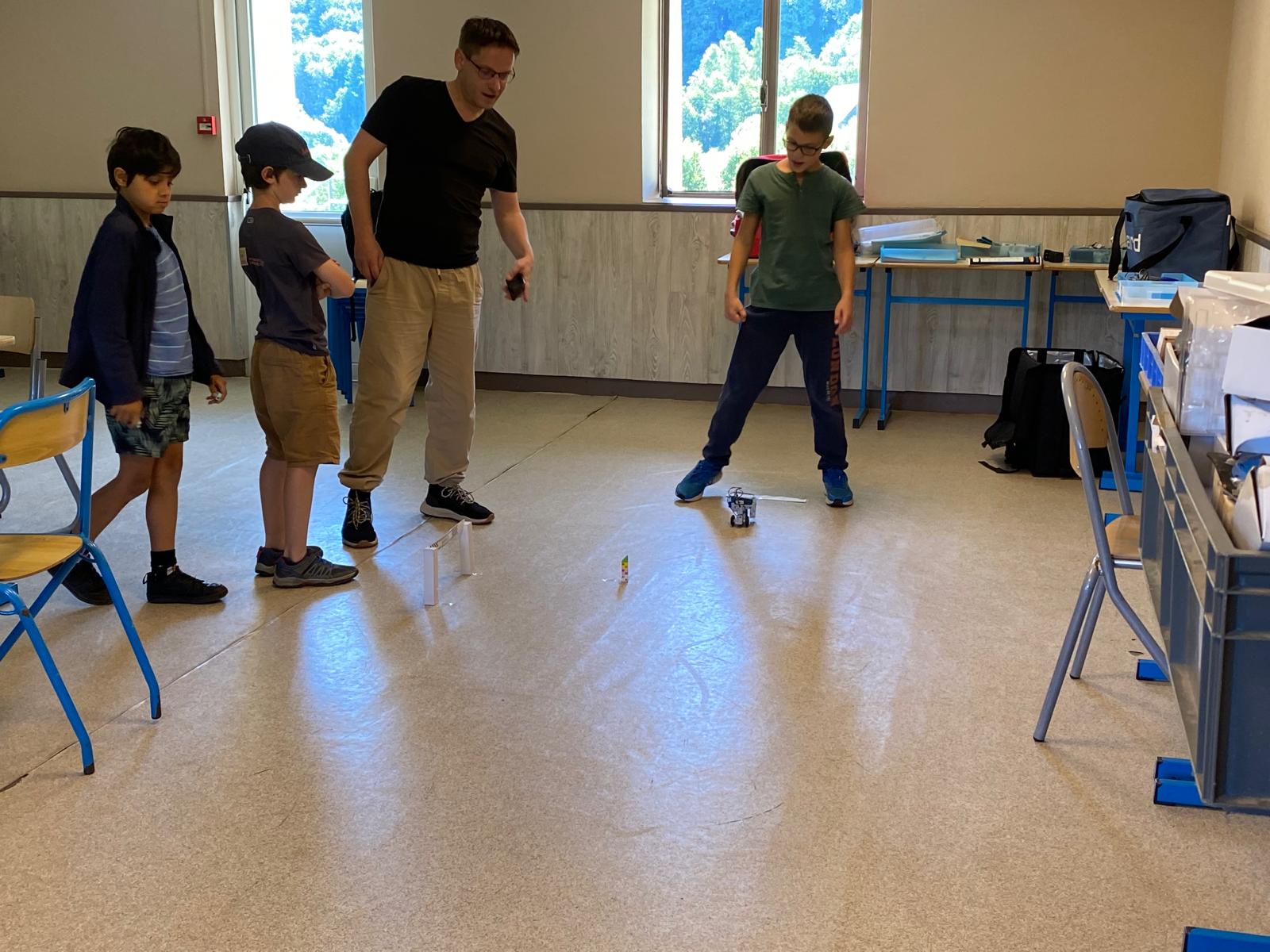 Groupe d'apprentis ingénieurs codant leur robot en colo gocolo