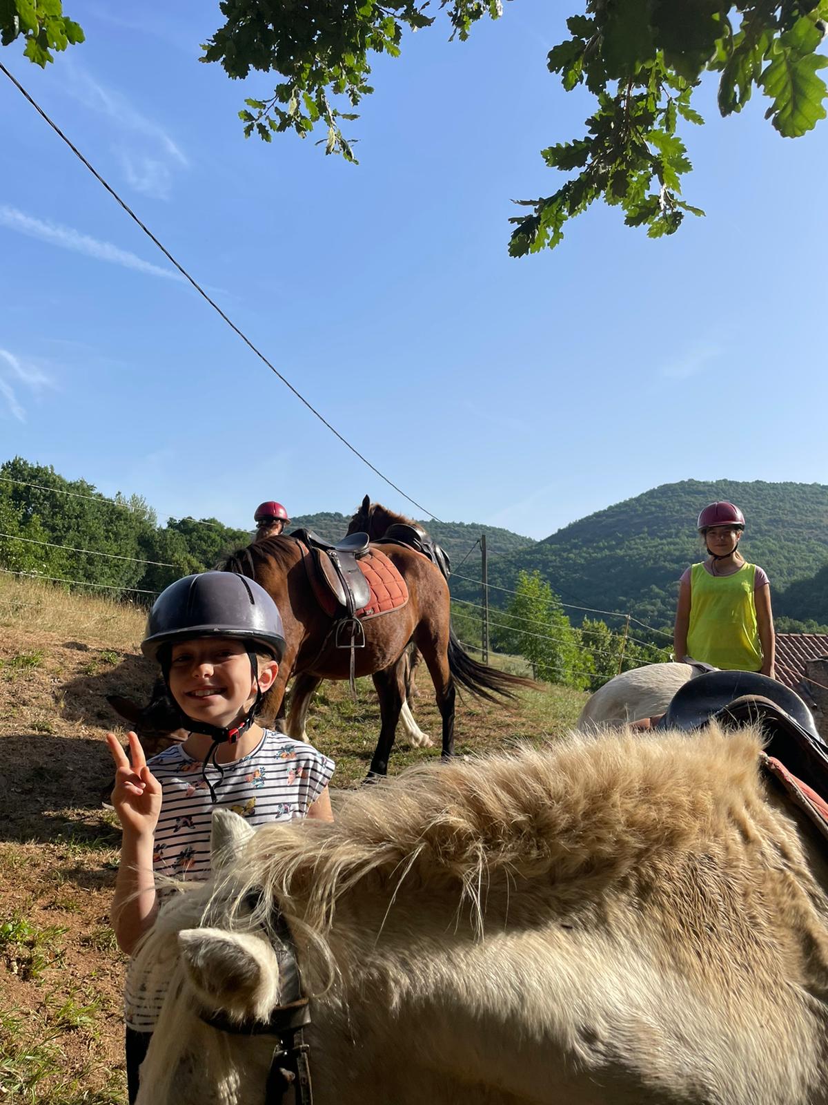 Enfants faisant connaissance avec leur poney en colo initiation Aveyron